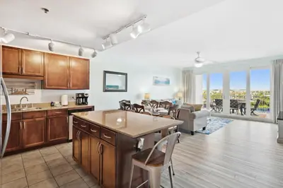 a kitchen and living room with a table and chairs at Remodeled 3BD plus Bunks! Low Floor Family Beach Resort! 5 Pools! by Dolce Vita Getaways PCB in Panama City Beach