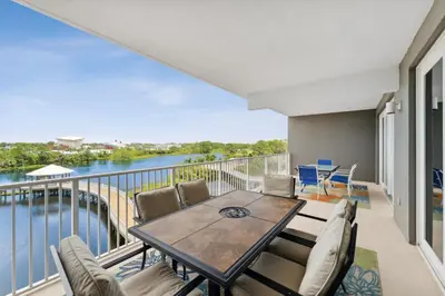 a balcony with a table and chairs and a view of the water at Remodeled 3BD plus Bunks! Low Floor Family Beach Resort! 5 Pools! by Dolce Vita Getaways PCB in Panama City Beach