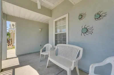 a porch with two chairs and a table and a window at 1 Mi to Beach Family-Friendly Home in PCB! in Panama City Beach