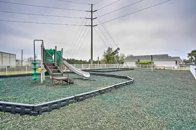 a playground with a slide on a gravel field at 1 Mi to Beach Family-Friendly Home in PCB! in Panama City Beach