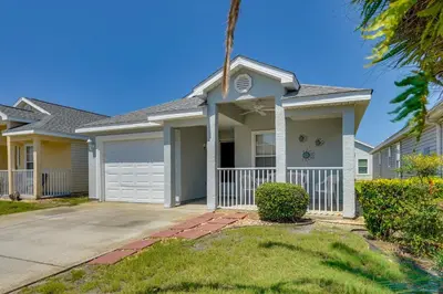 a house with a palm tree in front of it at 1 Mi to Beach Family-Friendly Home in PCB! in Panama City Beach