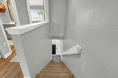 a staircase in a house with white walls and a window at Playa Tortuga-5 min walk to the beach in Panama City Beach