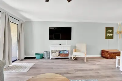 a living room with a flat screen tv on a white wall at Playa Tortuga-5 min walk to the beach in Panama City Beach