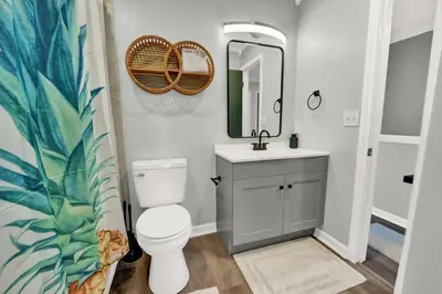 a bathroom with a toilet and a sink and a mirror at Playa Tortuga-5 min walk to the beach in Panama City Beach