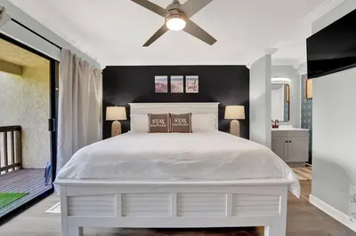 a bedroom with a white bed and a ceiling fan at Playa Tortuga-5 min walk to the beach in Panama City Beach