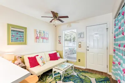 a living room with a couch and a ceiling fan at Breezy PCB Vacation Rental with Lanai, Walk to Ocean in Panama City Beach