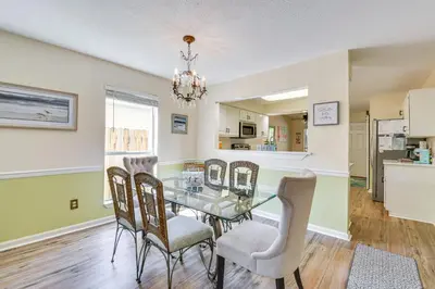 a dining room with a glass table and chairs at Breezy PCB Vacation Rental with Lanai, Walk to Ocean in Panama City Beach