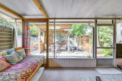 a living room with a couch and a large window at Breezy PCB Vacation Rental with Lanai, Walk to Ocean in Panama City Beach