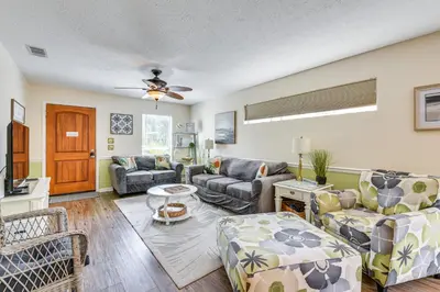 a living room with couches and a ceiling fan at Breezy PCB Vacation Rental with Lanai, Walk to Ocean in Panama City Beach