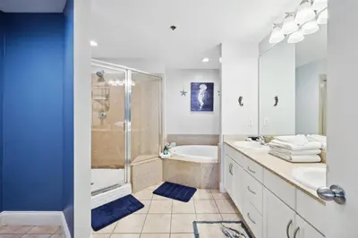 a bathroom with a shower and a sink and a tub at Laketown Wharf #1006 by Nautical Properties in Panama City Beach