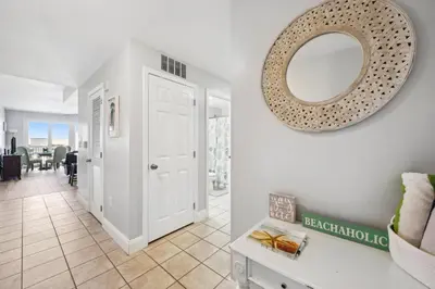a hallway with a white door and a mirror on the wall at Laketown Wharf #1006 by Nautical Properties in Panama City Beach