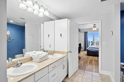 a bathroom with two sinks and blue walls at Laketown Wharf #1006 by Nautical Properties in Panama City Beach