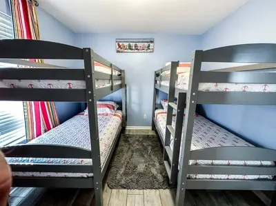 two bunk beds in a room with blue walls at Vacation Home near Beach and Waterpark! in Panama City Beach