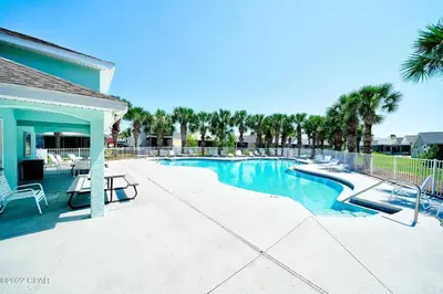 a swimming pool in a resort with a table and chairs at Vacation Home near Beach and Waterpark! in Panama City Beach