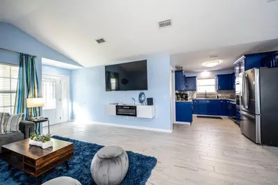 a living room with blue walls and a kitchen at Vacation Home near Beach and Waterpark! in Panama City Beach