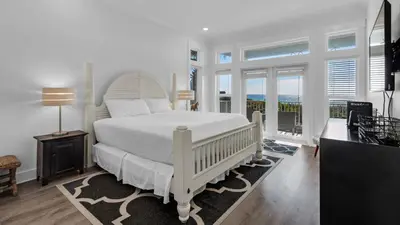 a bedroom with a white bed and a balcony at Turtle Beach - 55 Nature Way #100 in Santa Rosa Beach