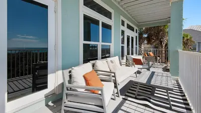 a porch with white chairs and a view of the ocean at Turtle Beach - 55 Nature Way #100 in Santa Rosa Beach