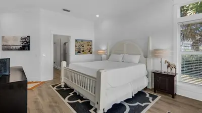 a white bedroom with a white bed and a window at Turtle Beach - 55 Nature Way #100 in Santa Rosa Beach