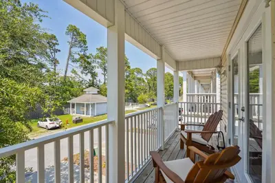 a porch with rocking chairs and a view of a house at Panama City Beach Vacation Rental about 1 Mi to Beach! in Panama City Beach
