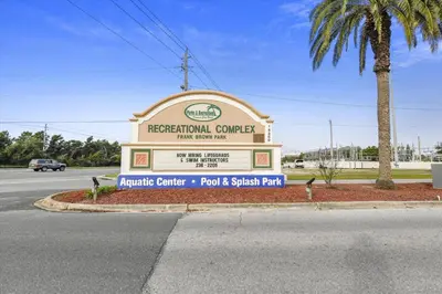 a sign for a recreational center with a palm tree at Cove Cottage - 3 Bedroom withPrivate Pool, Sleeps 6, Quiet Community, Close to Fishing Marinas, home in Panama City