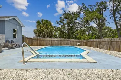 a swimming pool in a backyard with a wooden fence at Cove Cottage - 3 Bedroom withPrivate Pool, Sleeps 6, Quiet Community, Close to Fishing Marinas, home in Panama City