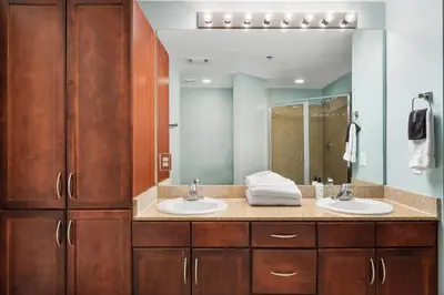 a bathroom with two sinks and a large mirror at Laketown Wharf #1707 by Nautical Properties in Panama City Beach