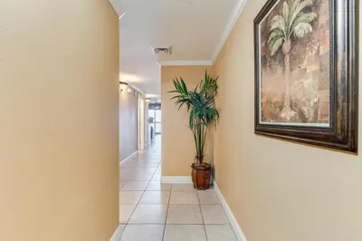 a hallway with a painting on the wall and a plant at Calypso Resort Serenity 1 in Panama City Beach