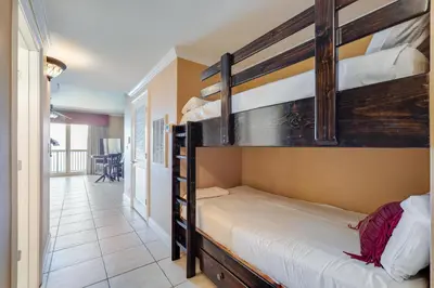 a bedroom with two bunk beds and a hallway at Calypso Resort Serenity 1 in Panama City Beach