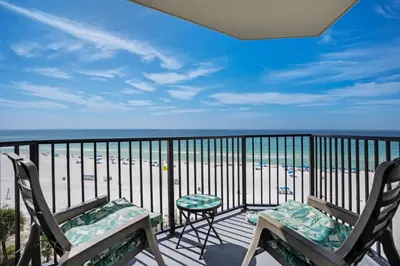 a balcony with two chairs and a view of the beach at Sunbird 604W in Panama City Beach