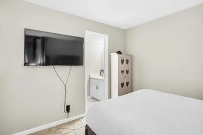 a bedroom with a bed and a flat screen tv at Sunbird 604W in Panama City Beach