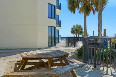 a wooden picnic table in front of a building at Sunbird 604W in Panama City Beach