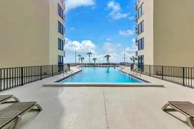 a swimming pool in the middle of two tall buildings at Sunbird 604W in Panama City Beach