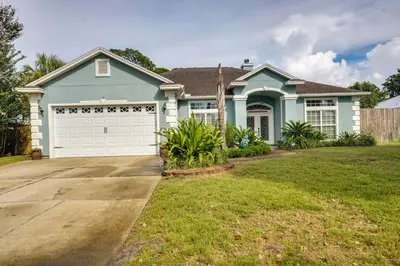 a blue house with a white garage at Pet-Friendly Panama City Beach Home Near Beaches! in Panama City Beach