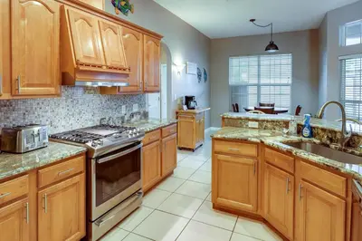 a kitchen with wooden cabinets and stainless steel appliances at Pet-Friendly Panama City Beach Home Near Beaches! in Panama City Beach