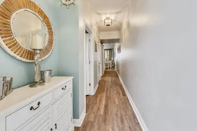 a hallway with a white dresser and a mirror at Shores of Panama 2326 - 1 Bedroom Bunks Sleeps 6, Reserved Parking! condo in Panama City Beach