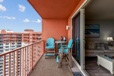 a balcony with chairs and a table and a couch at Shores of Panama 2326 - 1 Bedroom Bunks Sleeps 6, Reserved Parking! condo in Panama City Beach