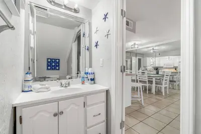 a white bathroom with a sink and a mirror at Beach, pools, tennis, Gulf Highlands Beach Resort in Panama City Beach