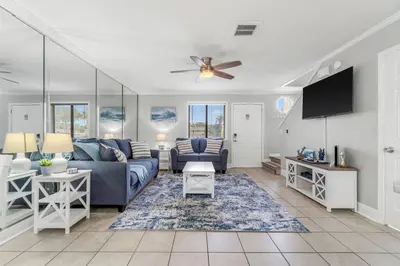 a living room with a couch and a tv at Beach, pools, tennis, Gulf Highlands Beach Resort in Panama City Beach