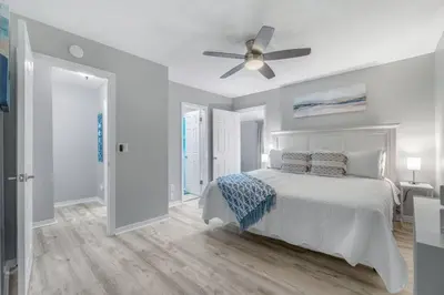 a white bedroom with a bed and a ceiling fan at Beach, pools, tennis, Gulf Highlands Beach Resort in Panama City Beach