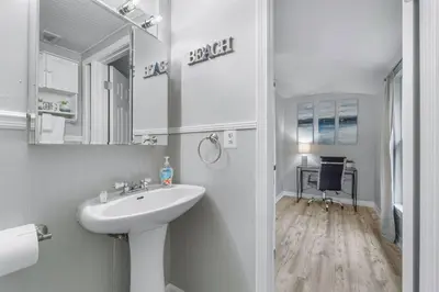 a white bathroom with a sink and a mirror at Beach, pools, tennis, Gulf Highlands Beach Resort in Panama City Beach