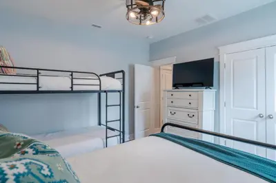 a bedroom with two bunk beds and a tv at Sand's Hideaway in Panama City Beach