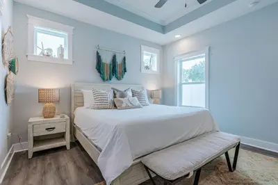 a bedroom with a white bed and a window at Sand's Hideaway in Panama City Beach