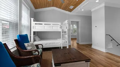 a room with bunk beds and a table and chairs at Seagrove Serenity in Santa Rosa Beach
