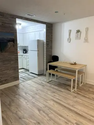 a kitchen with a table and a white refrigerator at FullyRenovated 1 min walk2 beach.5min to peir park in Panama City Beach