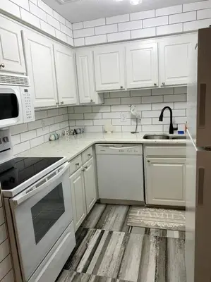 a kitchen with white appliances and white cabinets at FullyRenovated 1 min walk2 beach.5min to peir park in Panama City Beach