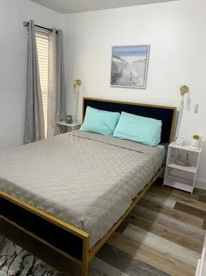 a bedroom with a large bed with blue pillows at FullyRenovated 1 min walk2 beach.5min to peir park in Panama City Beach