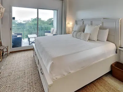 a bedroom with a large white bed and a balcony at Inn At Seacrest 303 - Seaside Sunrise in Rosemary Beach