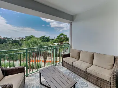 a living room with a couch and a table on a balcony at Inn At Seacrest 303 - Seaside Sunrise in Rosemary Beach