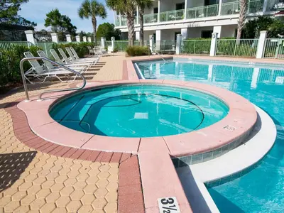 a large swimming pool in a resort with chairs around it at Inn At Seacrest 303 - Seaside Sunrise in Rosemary Beach
