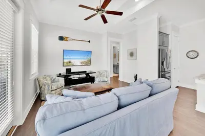 a living room with a couch and a piano at Town of Prominence 80C- The Wright Place in Santa Rosa Beach